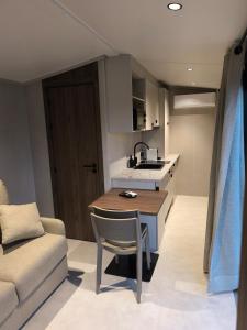 a small kitchen with a table and a couch at Tiny House ALPEA in Fillinges