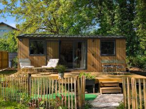 a wooden cabin with a table and chairs in a yard at Tiny House ALPEA in Fillinges