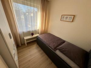 a small bedroom with a bed and a window at Haus-36 in Neuss +17 photos