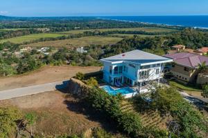 an aerial view of a blue house on a hill at Casa La Cima in Playa Hermosa