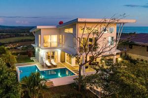 a house with a swimming pool in front of the ocean at Casa La Cima in Playa Hermosa