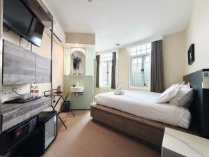 a bedroom with a large bed and a flat screen tv at A Hotel Chinatown in Singapore