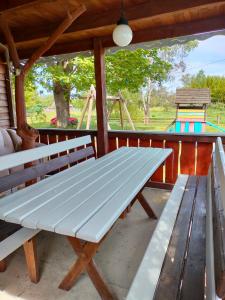 a picnic table on a porch with a playground at Cottage in Pulemets