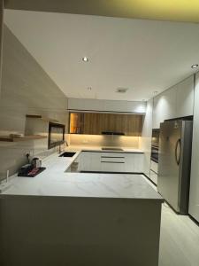a large kitchen with white counters and stainless steel appliances at Luna Villa in Al Khobar