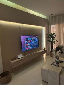 a living room with a flat screen tv on a wall at Luna Villa in Al Khobar