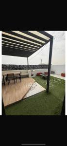 a picnic table and benches under a pavilion at Luna Villa in Al Khobar