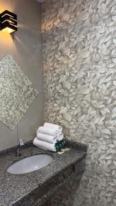 a bathroom with a sink and towels on a counter at Hotel Gênova BC in Balneário Camboriú +29 photos