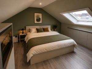 a bedroom with a large bed and a skylight at L' Gante in Ghent