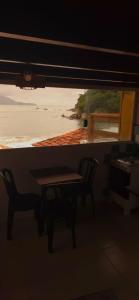 a table and a chair in a room with a window at Bem Me Quer - Hospedagem in Trindade