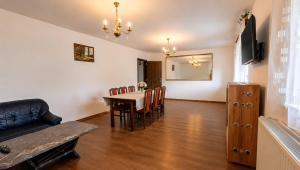a dining room with a table and chairs and a television at Pensiunea Alpin Marisel Self Check-in in Mărişel