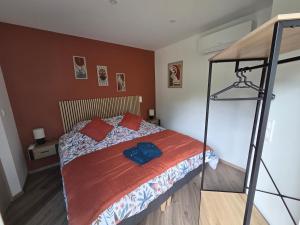 a bedroom with a bed with red pillows and a ladder at Le Petit L Orée des Bois in Blainville-sur-lʼEau