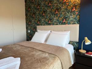 a bedroom with a large bed with a floral wallpaper at Na Outra Margem - Douro River Views - Free Parking in Vila Nova de Gaia
