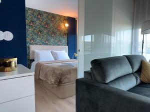 a bedroom with a bed and a couch in a room at Na Outra Margem - Douro River Views - Free Parking in Vila Nova de Gaia