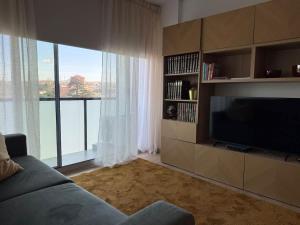 a living room with a couch and a flat screen tv at Na Outra Margem - Douro River Views - Free Parking in Vila Nova de Gaia