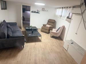a living room with a couch and a chair and a table at SeaSide Villa in Ashdod
