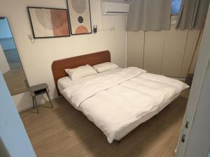 a bed with two pillows in a small room at SeaSide Villa in Ashdod
