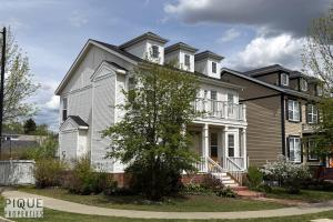 a large white house with a brown at The Obsolete Suite - HotTub - King Bed - AC - Pet Friendly in Edmonton