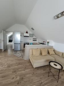 a white living room with a couch and a kitchen at Hotel Guesthouse Stari Jasen in Zagreb