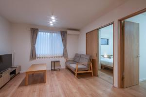 a living room with a couch and a table at treehouse - Vacation STAY 22128 in Nagoki