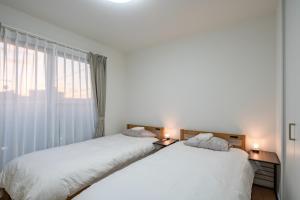 two beds sitting next to each other in a bedroom at treehouse - Vacation STAY 22128 in Nagoki