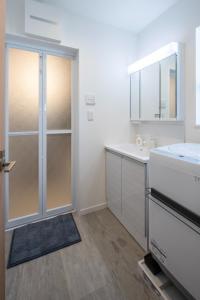 a white bathroom with a sink and a shower at treehouse - Vacation STAY 22128 in Nagoki +9 photos