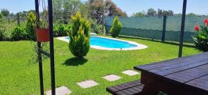 a backyard with a swimming pool and a wooden table at Los 3 Gurises in Gualeguay