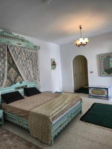 a bedroom with two beds and a chandelier at Morjana Castle in Sousse