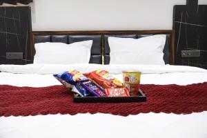 a tray of chips and snacks on a bed at The Glam By Sandane Homes in Greater Noida
