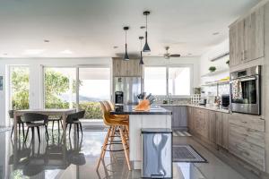 a kitchen with wooden cabinets and a island with bar stools at Casa La Cima in Playa Hermosa