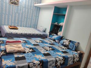 a bedroom with two twin beds and a blue wall at Auro Delight - Near Auroville in Pondicherry in Villupuram