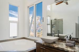 a bathroom with a large tub and a sink and a large window at Casa La Cima in Playa Hermosa +52 photos
