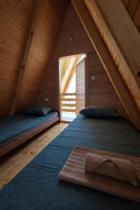 a attic bedroom with two beds and a window at Medeni brijeg in Donji Potok