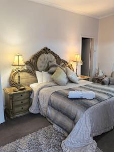 a bedroom with a large bed with two towels on it at Ronique's Guest House in Rustenburg