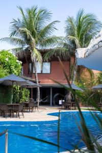 a resort with palm trees and a swimming pool at Aruanã Eco Praia Hotel in Aracaju