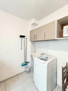 a small kitchen with a washer and dryer at Acomodações Azaleias by Rental in Palhoça +269 photos