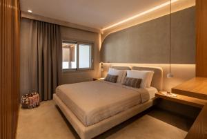 a bedroom with a bed and a window at Pefki Luxury Suites in Telendos +37 photos
