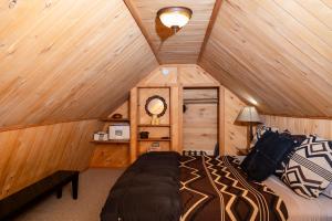 a bedroom with a bed in a wooden cabin at Riverview Cabin at O-Bar-O in Durango