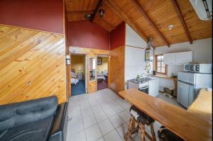 a kitchen with wooden walls and a wooden table at Apart Hotel y Cabañas Valle Exploradores in Puerto Tranquilo