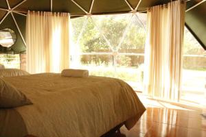 a bedroom with a bed and a large window at Sky Domos Pachar in Pachar