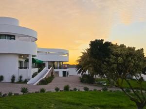 a white building with a slide in front of it at St Helena Bay Hotel in St. Helena Bay
