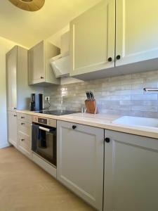 a kitchen with white cabinets and a sink at Ferienhaus Lykkehus Dümmer See in Hüde