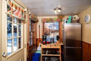 a kitchen with a stainless steel refrigerator and windows at Riverview Cabin at O-Bar-O in Durango