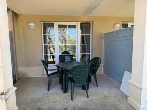 a table and chairs on a patio with a window at Lake view Appartment in Monflanquin