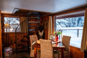 a dining room with a table and chairs and a ladder at Riverview Cabin at O-Bar-O in Durango +3 photos