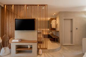 a living room with a television on a wall at Pefki Luxury Suites in Telendos