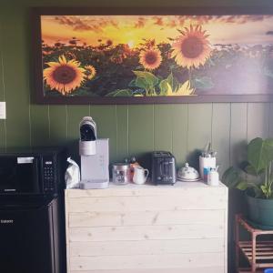 a kitchen with a coffee maker on a dresser next to a painting at Le nid marin in Gascons
