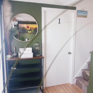 a hallway with a mirror and a dresser with a staircase at Le nid marin in Gascons