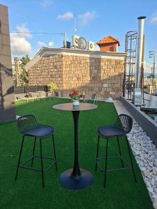 a patio with a table and two chairs on the grass at Railway studio 3 - Luxury Suite in Byblos - Central & Relaxing in Jbeil