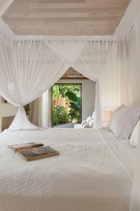 a bedroom with a white bed with a canopy at Casa do Amor Caraíva in Caraíva +52 photos