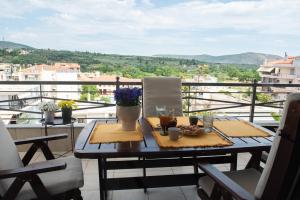 a table and chairs on a balcony with a view at Gela in Livadeia